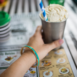 Blue hair tie in a gypsea loop bangle drinking a milk shake