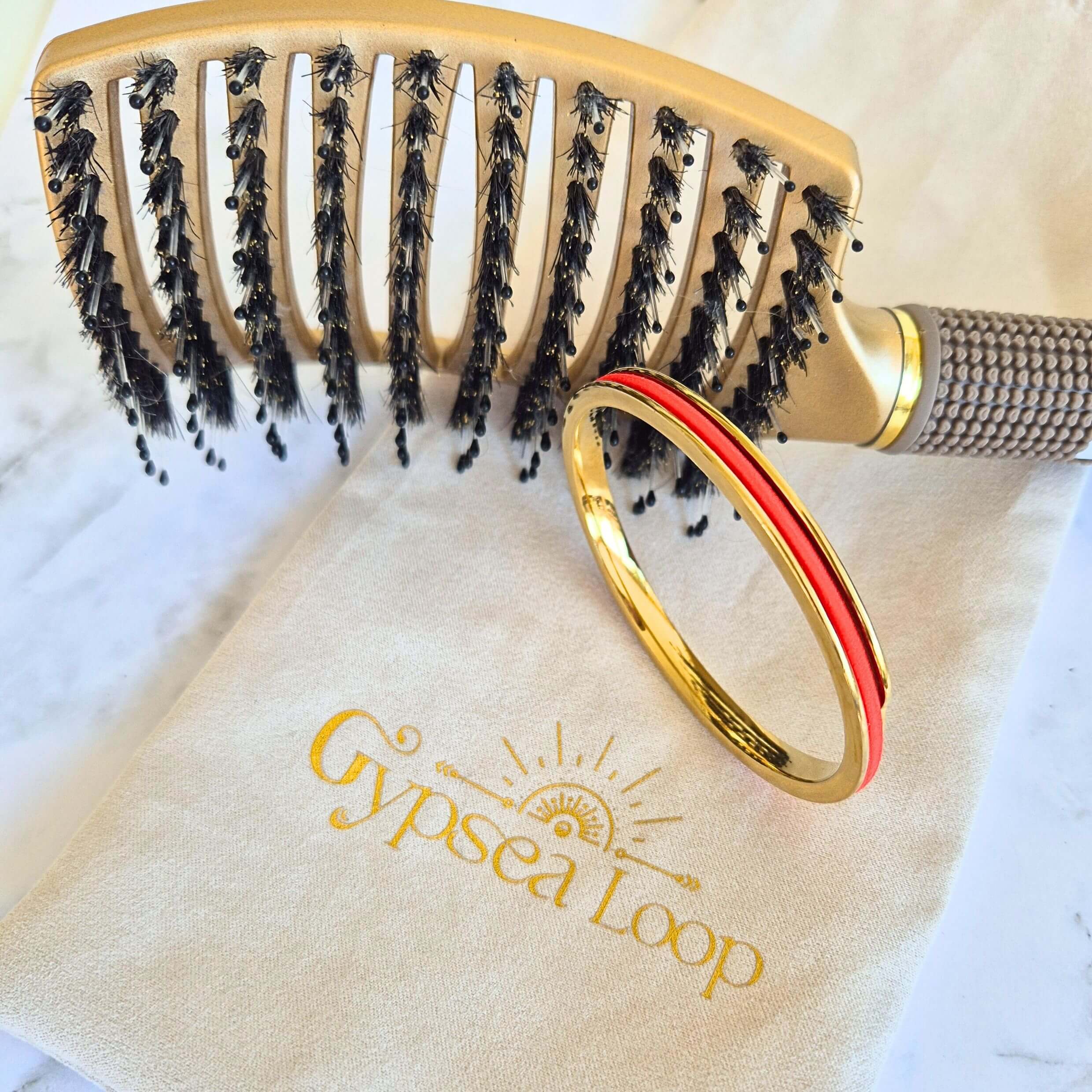 Gypsea loop Luxe Hair Brush with Gold bangle and red hair tie