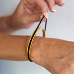 Gypsea loop hair tie bangle holds your hair tie in a secret groove. Available in Gold and Silver