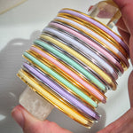 Light Pastel coloured hair ties in a stack of Gypsea Loop hair tie bangles. Gold and Silver 