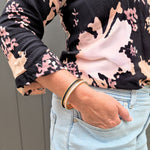 Light pink and black hair tie in a gold hair tie bangle made by Gypsea loop