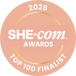 Badge for 2026 SHE-COM Awards Top 100 Finalist on a pink background